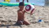 Child with Rattle ball on the beach - Real Eyes Sport, Italy