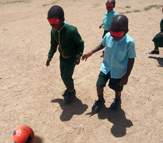 Børn der spiller med Apricot blindefodbold